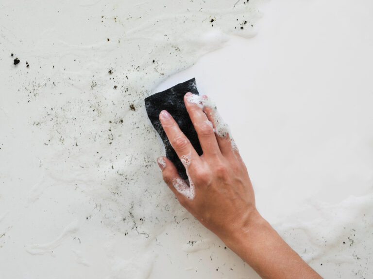 top view hand scrubbing dirt with sponge